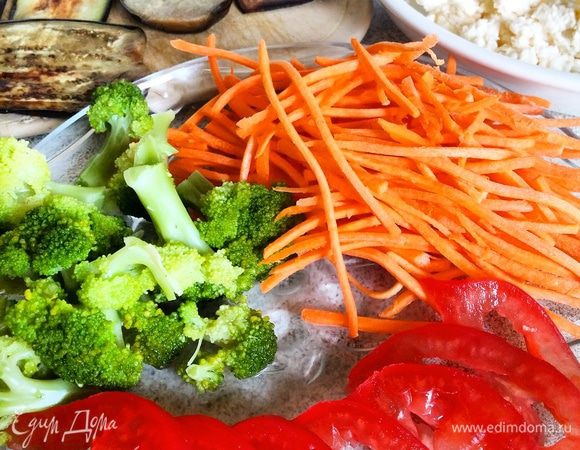 Брокколи отварить до готовности в подсоленной воде. Готовую брокколи можно полить растопленным сливочным маслом или соевым соусом (я не поливала).
Баклажаны нарезать вдоль на длинные тонкие полосы, сложить их в миску с подсоленной водой и оставить на 20 — 30 минут, затем воду слить. Полоски слегка обсушить и обжарить на растительном масле с двух сторон до готовности.
Чеснок и плавленный сыр натереть на терке, перемешать, посолить и поперчить по вкусу.
Помидор нарезать тонкими ломтиками, морковь натереть на «корейской» терке.