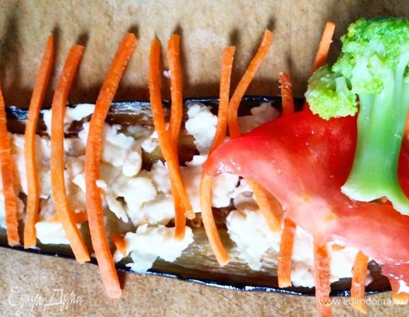 На полоску баклажана выложить сыр с чесноком, а затем овощи, как на фото. Скрутить рулет, начиная со стороны брокколи.