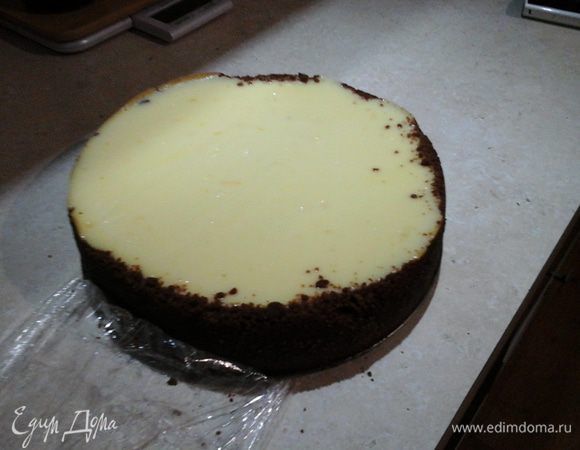 Духовку разогреваем до 200°С. Ставим в духовку пирог и выпекаем 11 — 12 минут. Убавляем жар до 105 —  110°С и оставляем на час-полтора. Проверяем десерт: если середина жидкая, а бока упругие, духовку можно выключать. Оставляем чизкейк в духовке до полного остывания, а затем, закрыв пленкой, помещаем в холодильник на 6 — 12 часов. Чем дольше, тем лучше.