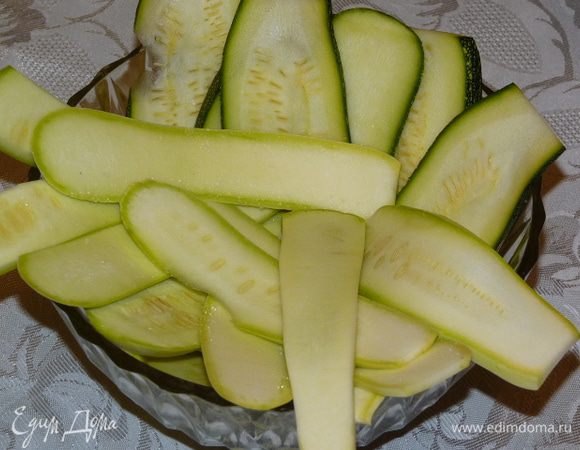 Тем временем нарезать цукини и кабачок вдоль и посолить.