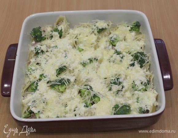 Полить ракушки сверху  сырным соусом и присыпать отложенным тертым сыром.