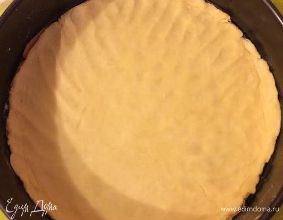 Духовку нагреть до 180°С. Форму 26 (см) смазать маслом и присыпать мукой. Тесто разделить на 3 части. Раскатать одну часть теста и выложить в форму.