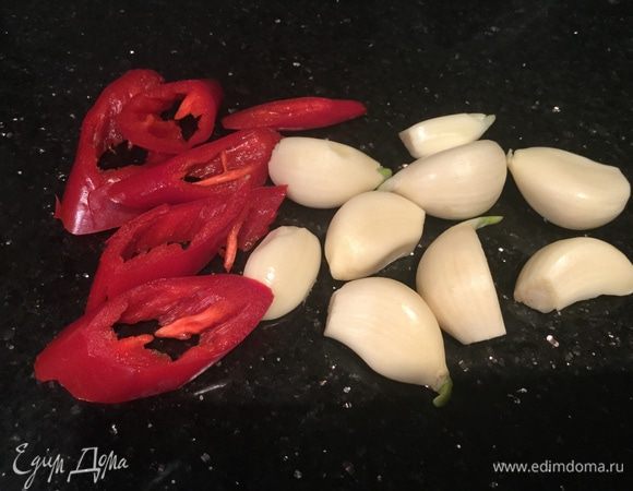 Очистите чеснок. Перец чили нарежьте тонкими полосками.