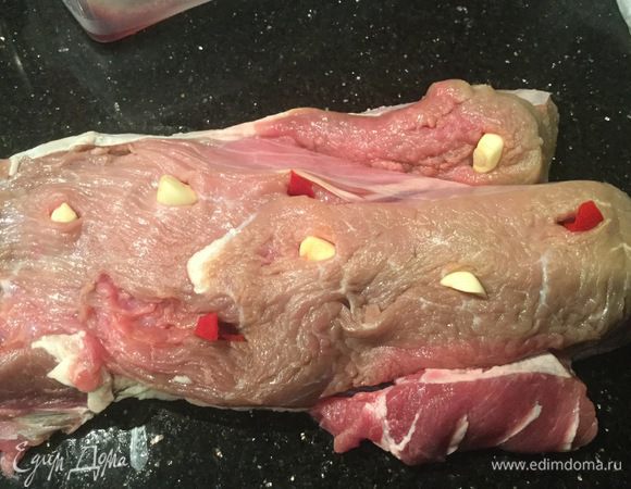 В говядине сделайте проколы острым ножом, вставьте перец и чеснок.
