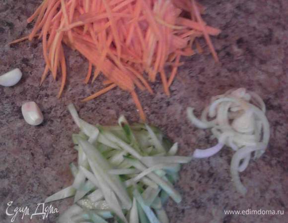 Нарезать с помощью специального ножа или натереть на терке морковь, тонкими полосочками нарезать огурец и лук, очистить чеснок.