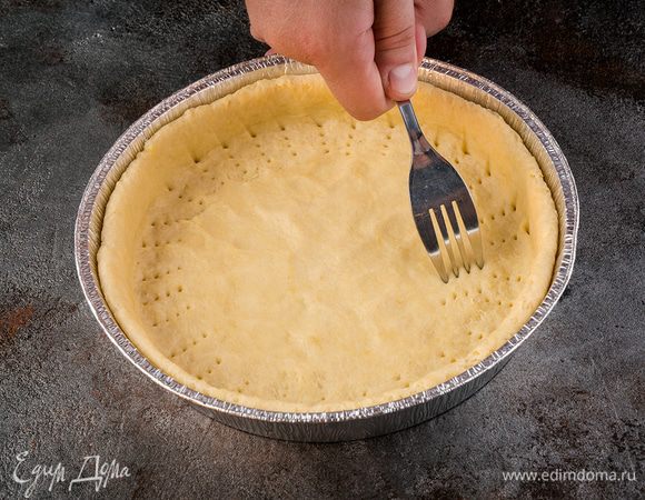 Круглую форму застелить пергаментом, сверху смазать масло с помощью кисточки. Дно наколоть вилкой и убрать в холодильник.
