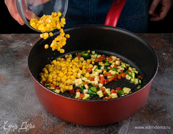Разогреть в сковороде 2 ст. ложки оливкового масла и обжарить перец.
Цукини, нарезанный кубиками перец чили и кукурузу и выложить к перцу.
