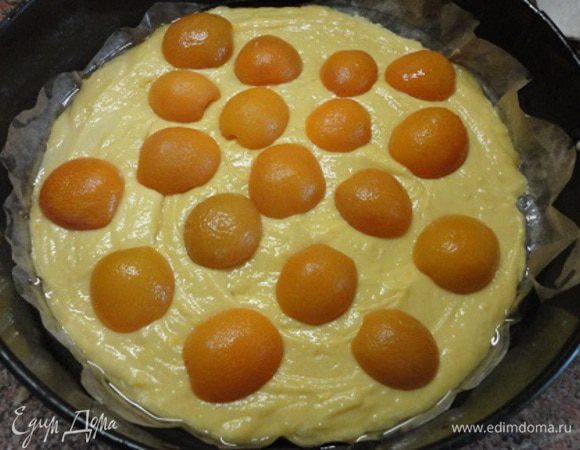 Форму диаметром 25 см (или прямоугольную) смазать маслом и выстлать дно пекарской бумагой. Вылить тесто тонким слоем, выложить абрикосы.