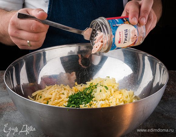 Картофель отварить, протереть на крупной терке. Нарезать лук, яйца отварить, нарезать на маленькие части. Сыр натереть на терке. Зелень мелко нарезать. Смешать продукты для начинки. Добавить консервированный тунец.