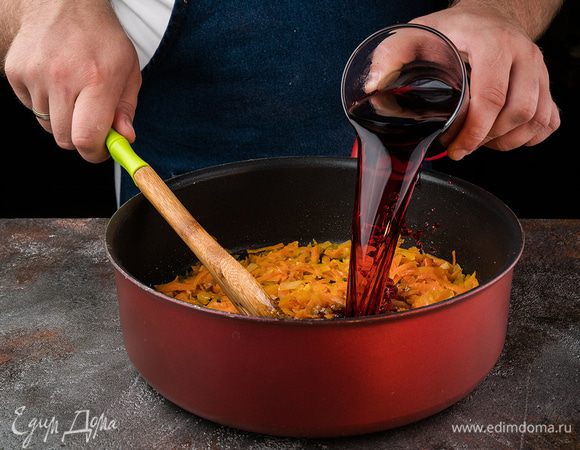 Мелко нарезать лук и морковь натереть на крупной терке. Все переложить в сковороду, предварительно полив ее оливковым маслом.Также добавить измельченный чеснок. Добавить вино.
