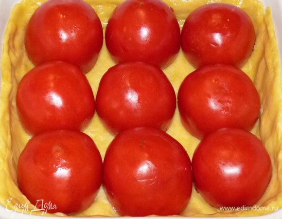 Выложить на тесто фаршированные помидоры срезом вниз.
