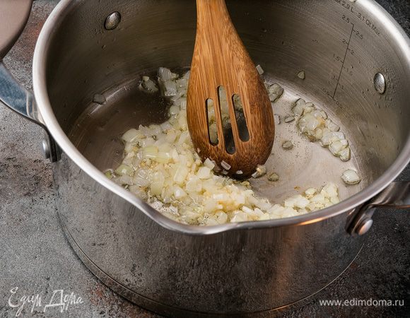 Очистите и мелко нарежьте лук и чеснок. В кастрюлю с толстым дном налейте растительное масло и обжарьте лук с чесноком.