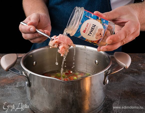 Влейте в кастрюлю 1,5 л горячей воды, доведите до кипения, добавьте тунца, приправьте солью и перцем, варите 10 минут.