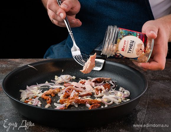 Затем добавить тунец. Поперчить, добавить травы, перемешать и прогреть.