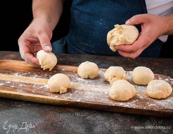 К этому времени тесто подошло. Выложить его на рабочую поверхность и поделить на равные части.