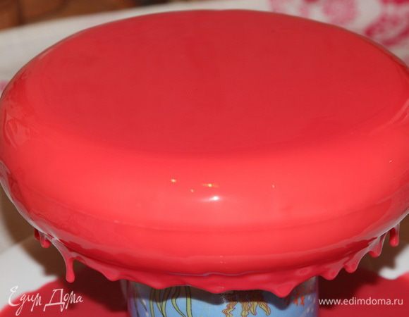 Я взяла большую чистую тарелку, перевернула на нее вверх донышком высокую чашку и поставила на нее торт. Теперь глазурью поливаем сначала бока торта и затем выливаем всю глазурь на середину торта. Вся лишняя глазурь стечет. Когда уже все — она перестанет стекать и будут висеть вот такие нити.