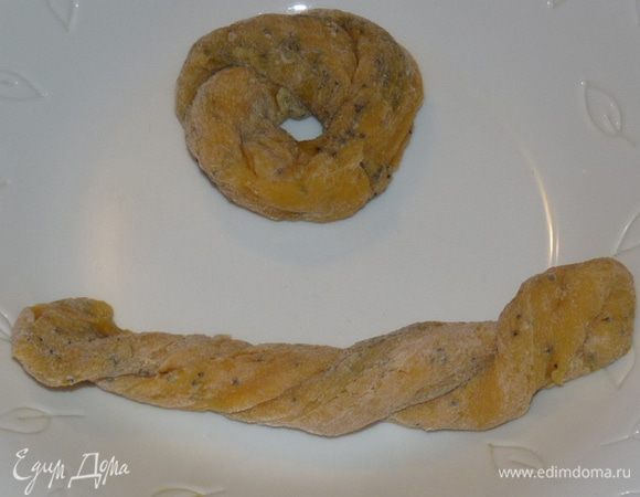 Из теста сформировать колбаску, разрезать на одинаковые кусочки. У меня получилось 12 штук. Каждый кусочек раскатать в длинную колбаску, сложить вдвое, закрутить. Свернуть бублики.