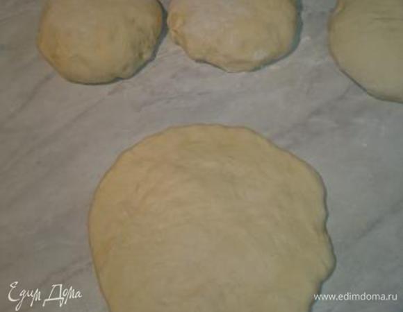 Пальцами, равномерно распластайте тесто в толщину 1,5 — 2 см и в диаметре сантиметров 25-30. 