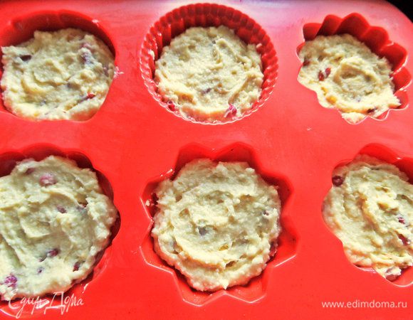 Соду погасить уксусом, влить в состав. Всыпать просеянную муку и крахмал, перемешать. Добавить кусочки груши или яблока, ягоды любые. Можно замороженные. Заполнить формочки не до краев. Поставить в духовку.