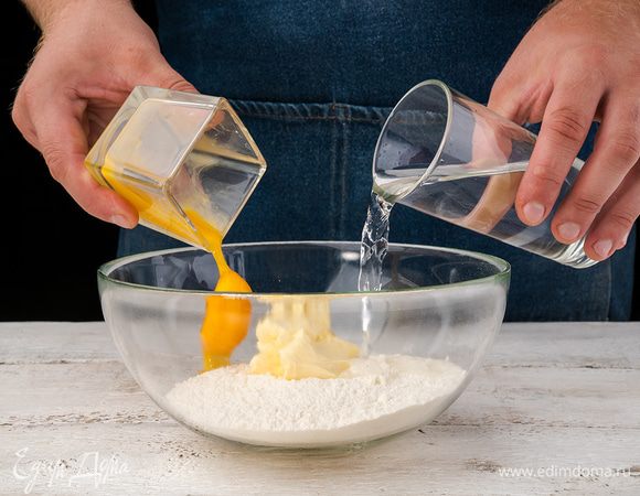 Из муки, соли, яичного желтка, 2 — 3 ложек холодной воды и нарезанного маленькими кусочками холодного сливочного масла замесить тесто. Завернуть в пленку и положить на 30 мин. в холодильник.