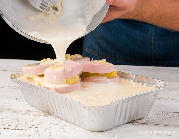 На слой картофеля выкладываем колбасу, нарезанную тонкими кружками, затем лук и чеснок, затем снова картофель и колбасу. Посыпать сверху мелко нарезанной петрушкой и залить запеканку яично-сметанной смесью.