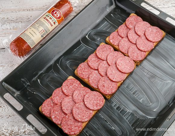 Выложить колбасу и засыпать сыром. 