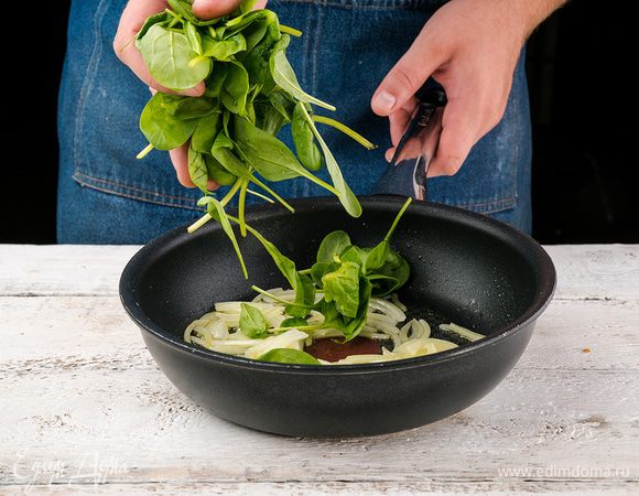 Шпинат промыть, обсушить. Лук нарезать. Разогреть оливковое масло в сковороде и пассеровать лук до прозрачности, добавить шпинат, посолить и поперчить, накрыть крышкой и дать шпинату осесть. Снять с огня и немного охладить. Сыр натереть на крупной терке.