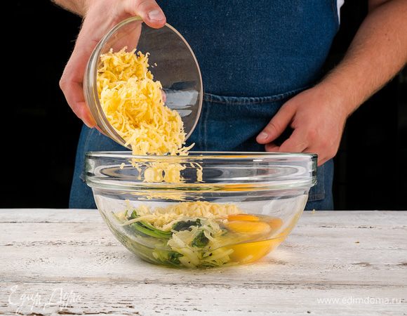 В остывший шпинат с луком разбить яйца, посолить, поперчить, добавить сыр (немного сыра оставить на посыпку), разболтать.