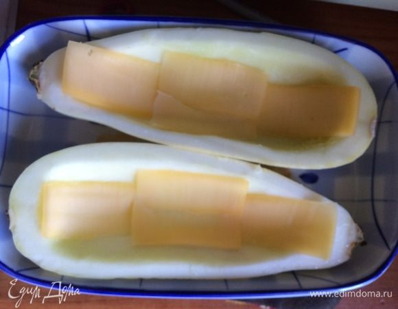 Помещаем наши лодочки в форму для запекания. Кладем внутрь несколько кусочков сыра.