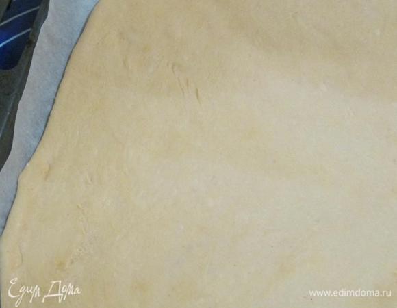 Тесто раскатать, выложить на противень, застеленный пекарской бумагой. Толщина коржа должна быть около 5 мм.