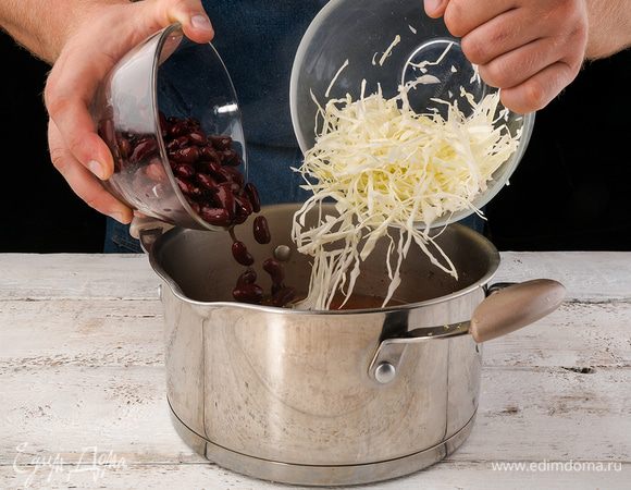 Капусту мелко шинкуем. Добавляем вместе с фасолью в суп, уменьшаем огонь и варим еще 15 минут. 