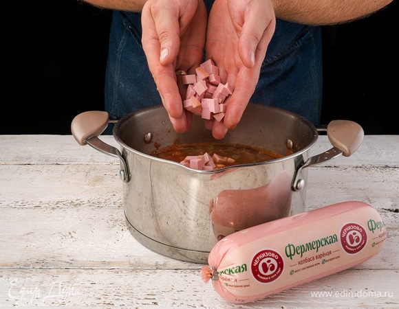 Колбасу нарезаем небольшими кусочками и кладем в суп. Солим-перчим, прогреваем в течение 3 — 4 минут.