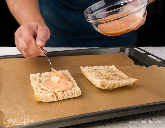 Смешиваем в миске майонез и кетчуп и смазываем хлеб.