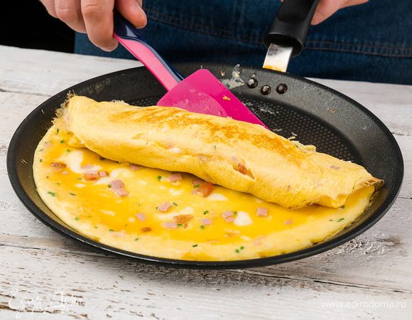 Продолжая сворачивать омлет с одного края в рулет, порциями доливать оставшуюся яичную массу. При необходимости смазывать кисточкой сковороду оливковым маслом.


