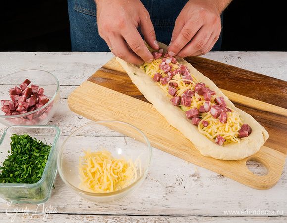 На зелень положить нарезанный сыр и колбасу.