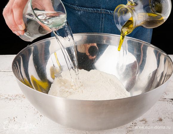 Слегка смажем противень. Или выложим бумагу для выпечки. Муку, соль и сахар, дрожжи смешаем в большой емкости.