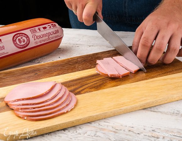 Колбасу нарезать кубиками, сырок натереть на крупной терке. Смешать колбасу с сырком и сметаной, завернуть начинку в блинчики.