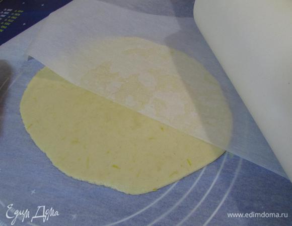 Через 15 минут раскатать тесто между двумя листами пергамента в пласт толщиной 4 мм.