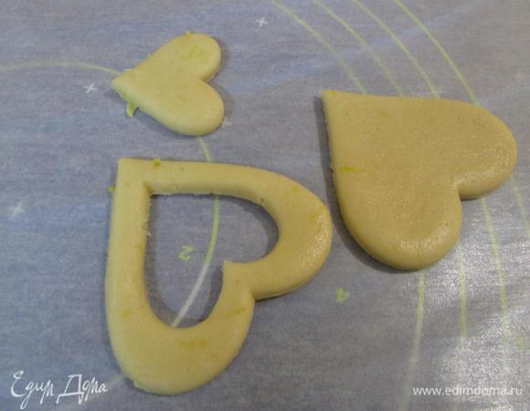 А другую половину разложить на рабочей поверхности. Формочкой поменьше вырезать из них сердечки-серединки.