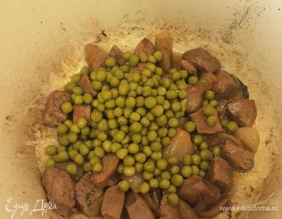 Когда мясо будет готово, добавить горошек и аккуратно перемешать. Снять с огня.