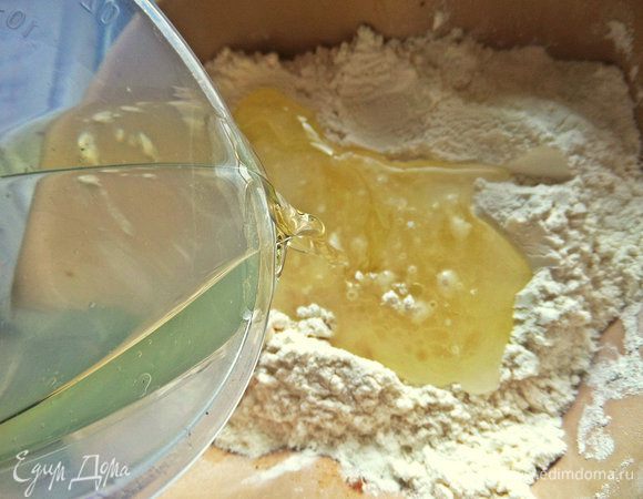 Доливаем воды в масло и вливаем в просеянную муку.