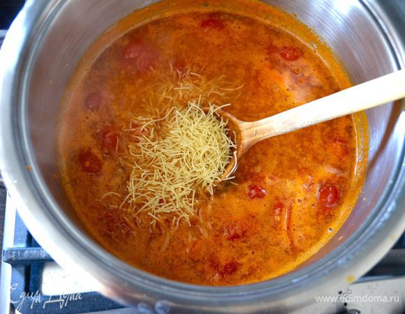 Залейте всё кипятком (или горячим бульоном) и дайте покипеть на слабом огне 5 минут. По рецепту, добавьте поломанные спагетти и варите ещё около 7 минут. Мне нравится использовать тоненькую вермишель («волосы ангела»), поэтому, я просто провариваю суп после добавления кипятка минут 10, затем добавляю поломанную вермишель, накрываю кастрюлю крышкой и выключаю огонь. Вермишелька сама доходит в супе.