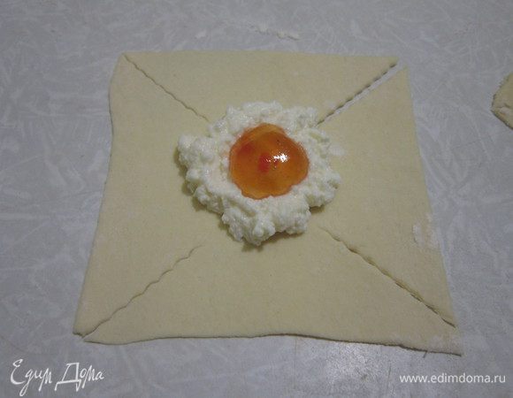 На квадраты выложить по 1 столовой ложке творога и 1 чайной ложке абрикосового джема.