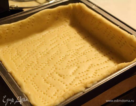 Через 1 — 2 часа вытащить тесто, раскатать примерно в 5 мм толщиной. Форму для выпечки тарта смазать сливочным маслом и слегка посыпать мукой, уложить в нее тесто, проколоть вилкой. 