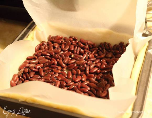 Внутрь на пекарскую бумагу выложить фасоль и отправить в разогретую до 180°С духовку на 15 минут.