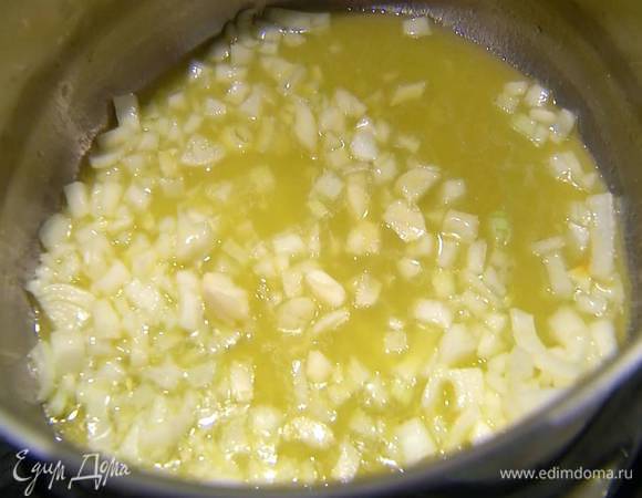 Разогреть в тяжелой кастрюле оливковое и сливочное масло, обжарить лук до прозрачности, затем добавить чеснок.