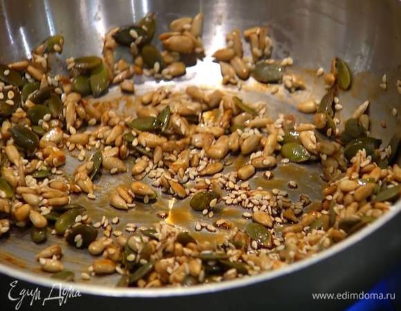 На разогретую сковороду выложить тыквенные и подсолнечные семечки, добавить кунжут, полить соевым соусом и обжарить до золотистого цвета.