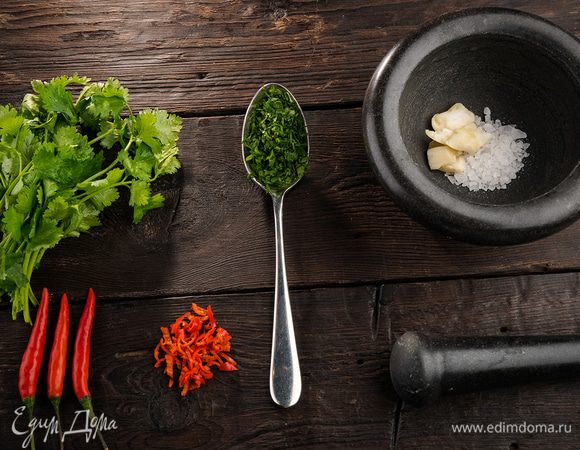 Перец чили, удалив семена, порубить. Чеснок почистить и растереть в ступке вместе с солью. Из половинки лимона выжать 2 ст. л. сока. Кинзу мелко порубить — должна получиться 1 ст. л.
