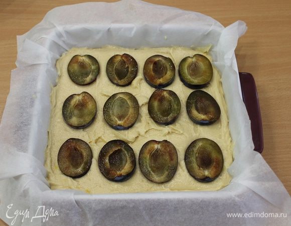 Выложить тесто в форму, сверху половинки слив, слегка вдавив их.