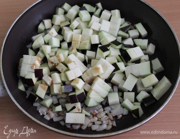 Лук обжарить на растительном масле, добавить нарезанный кубиками баклажан.